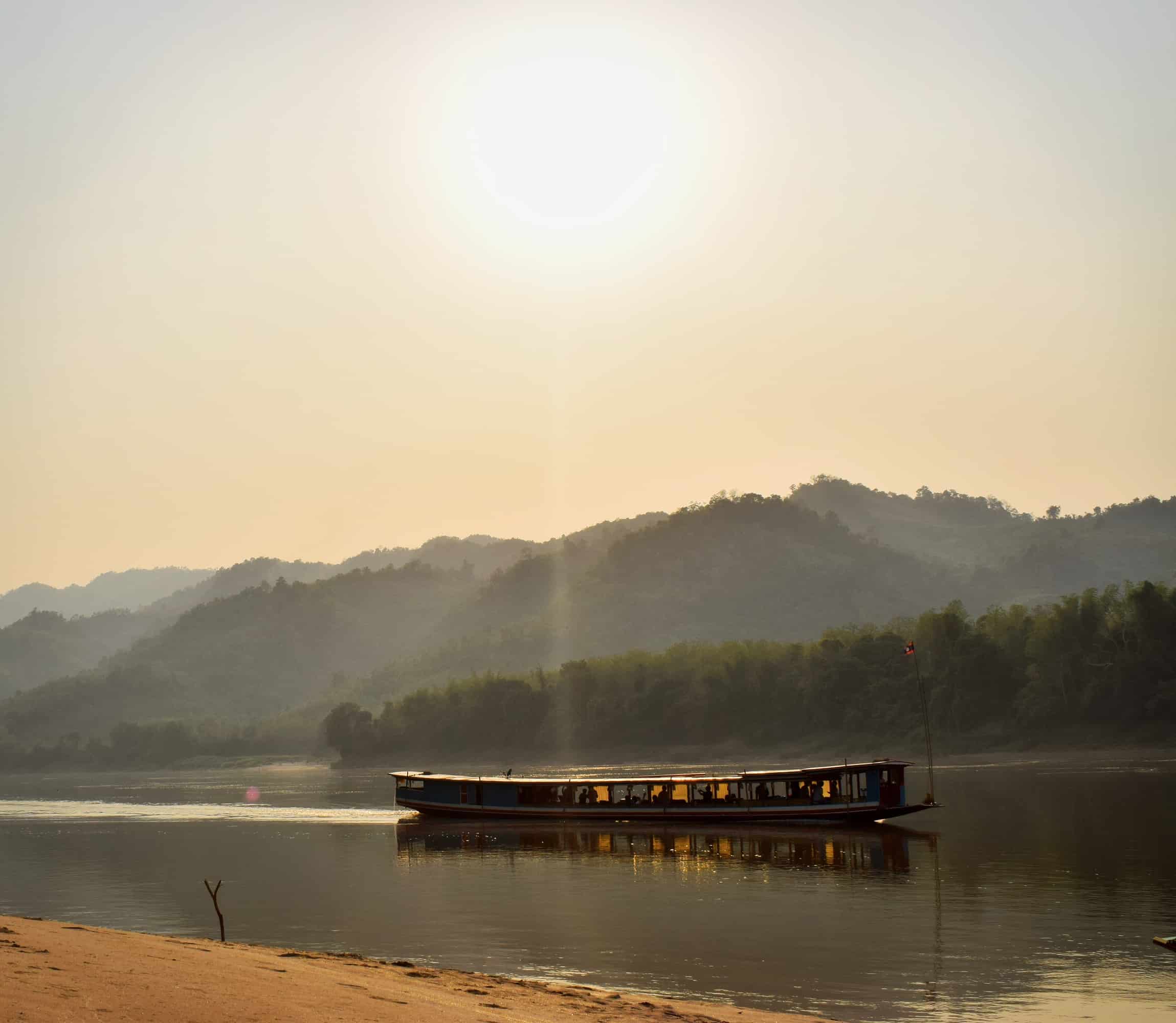 Sunset as a boat sails down the Mekong River in Laos Sunset as a boat sails down the Mekong River in Laos
