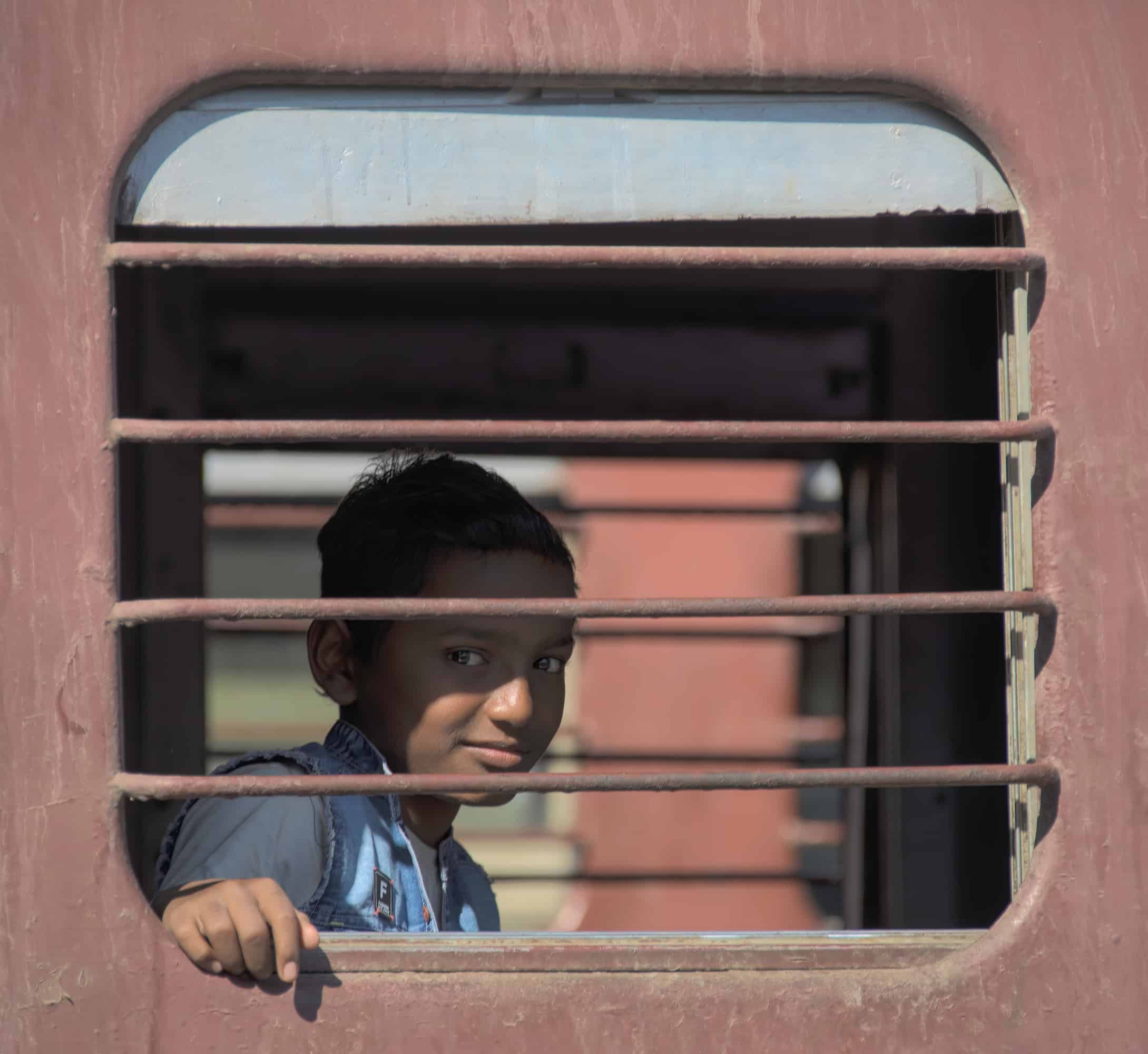 BoyInTrain Boy on a train in India looking out of window