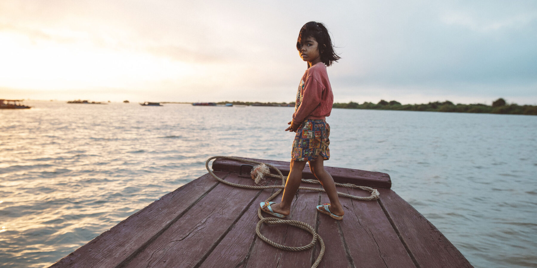 Child on the Tonle Sap Lake in Cambodia Child stood on boat on the Tonle Sap Lake in Cambodia