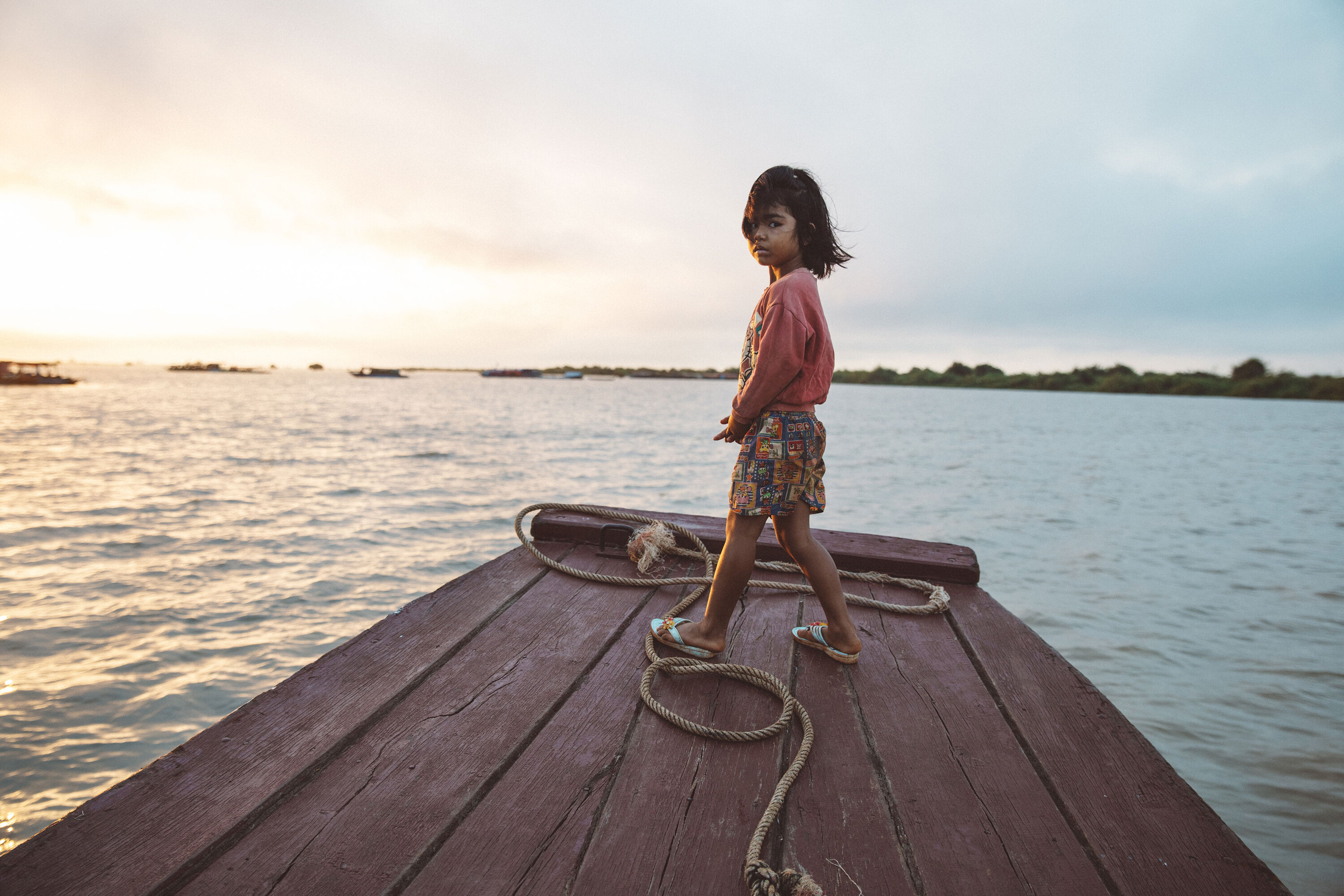 Child on the Tonle Sap Lake in Cambodia Child stood on boat on the Tonle Sap Lake in Cambodia