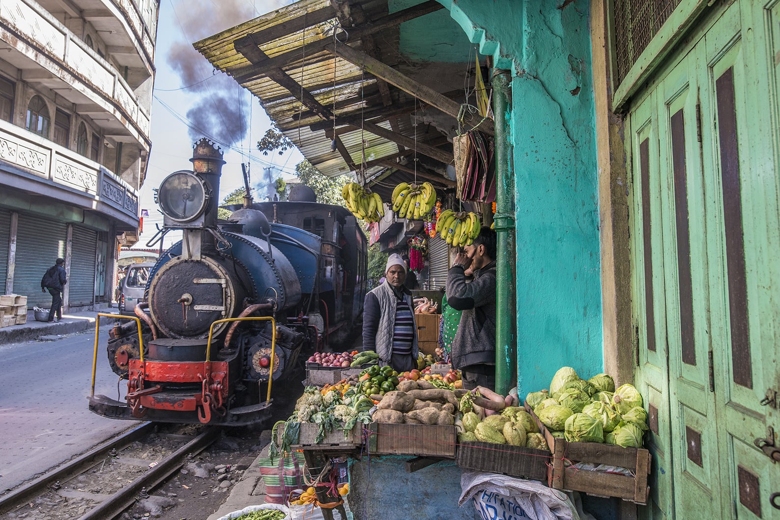 Toy train passing through a market in Darjeeling in India Toy train passing through a market in Darjeeling