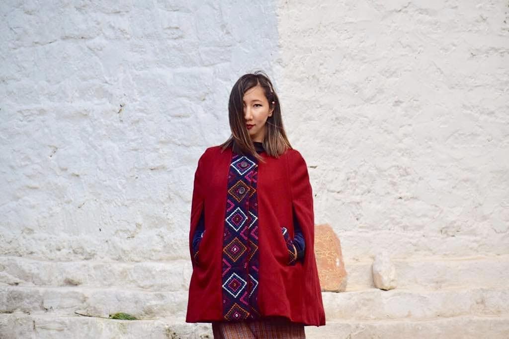 Geymit Geymit wearing a She Bhutan maroon cape yathra jacket