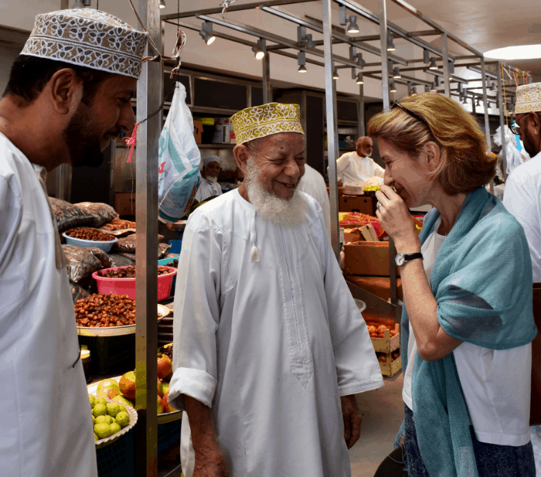 canvas Traveller laughing with guide in Oman market