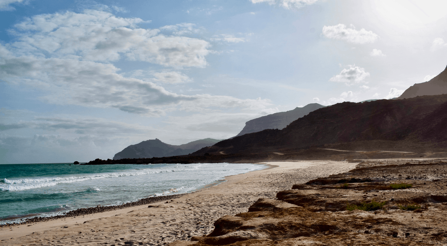 16 Beautiful beach in Oman with ocean and waves and mountains in the background