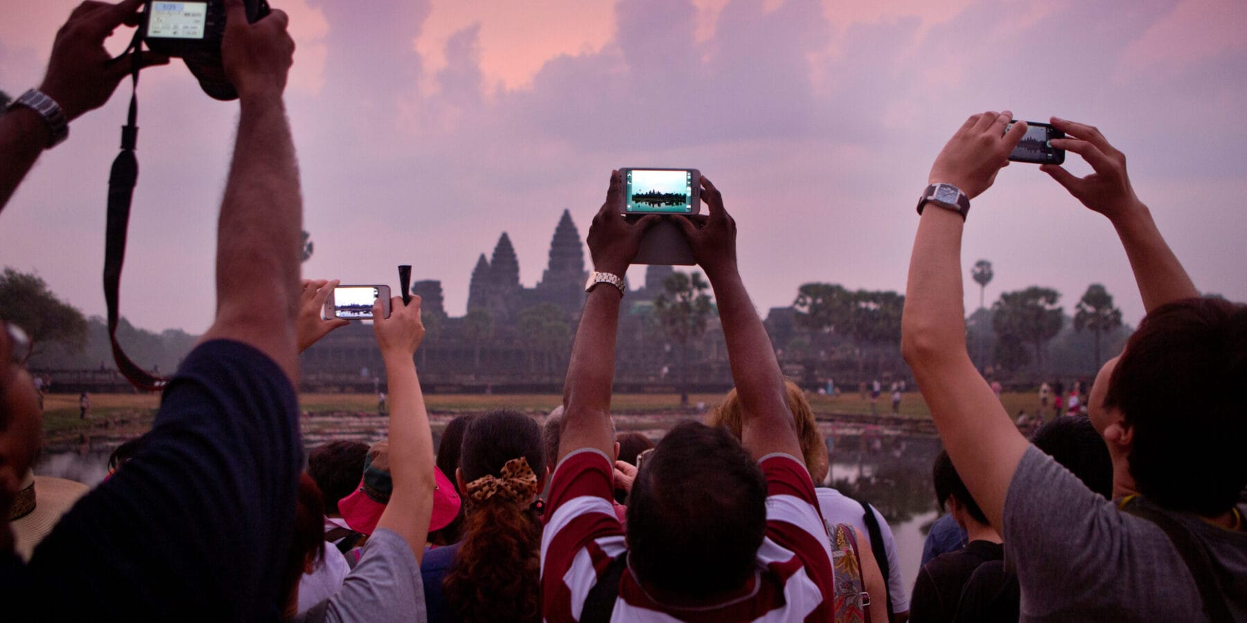 Photographing the dawn at Angkor Wat, waiting to see the light come up over the main temple of Angkor, Cambodia Taking a picture of Angkor Wat Sunrise