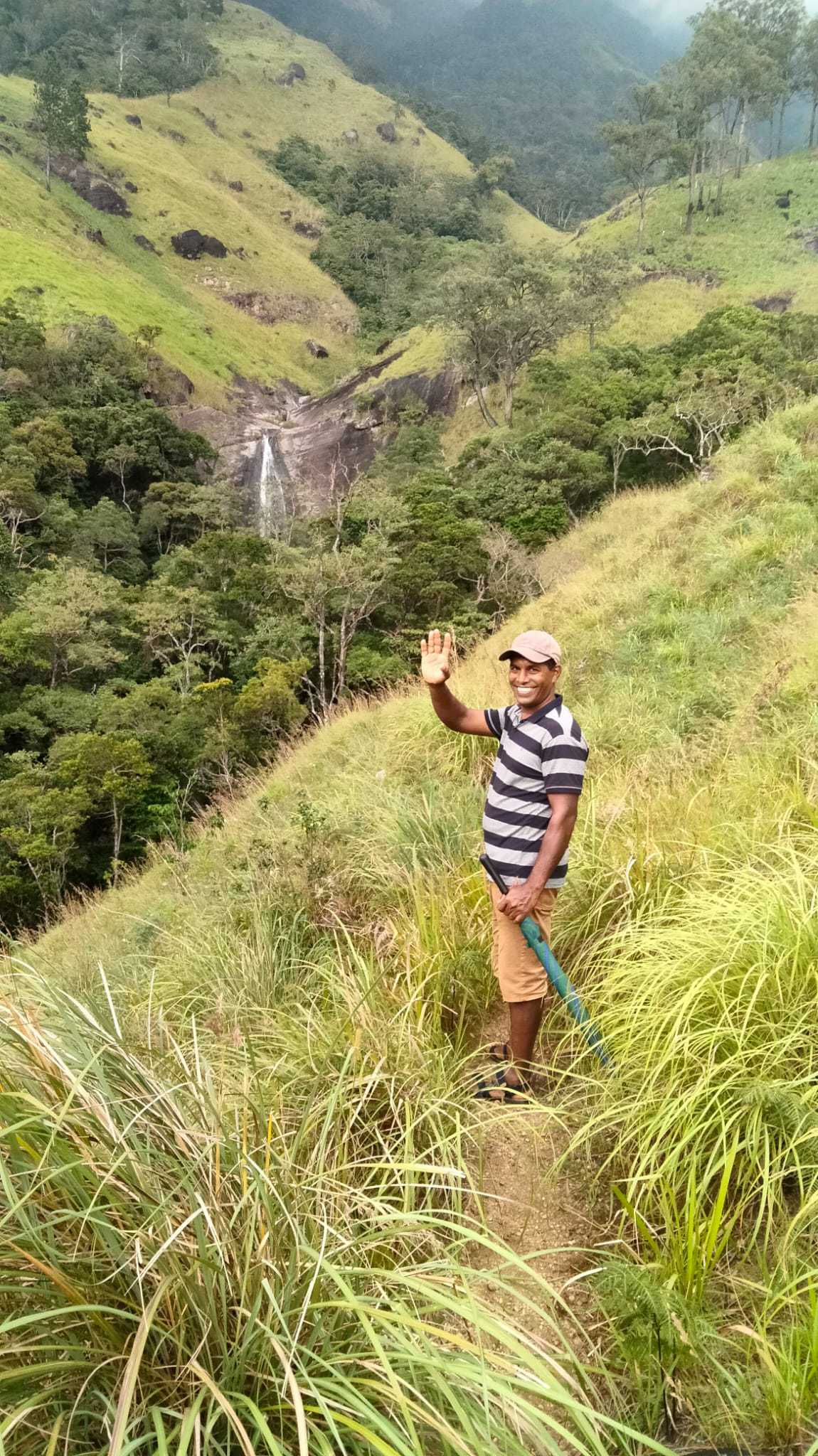 WhatsApp Image 2021-10-27 at 16.33.44 Trekking guide smiling with Lanka Ella waterfall in the background