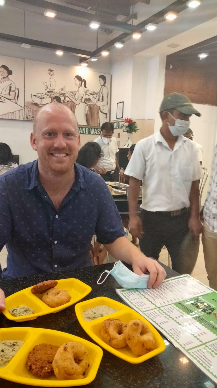 WhatsApp Image 2021-10-17 at 11.02.57 (1) A traveller eating in a restaurant in Kandy with staff wearing masks in the background