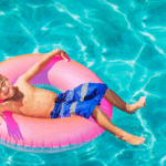 Thailand with Kids Young boy laying in a rubber ring in a swimming pool