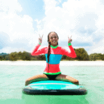 Thailand with Kids girl Young girl sitting on bodyboard along the coastline in Thailand