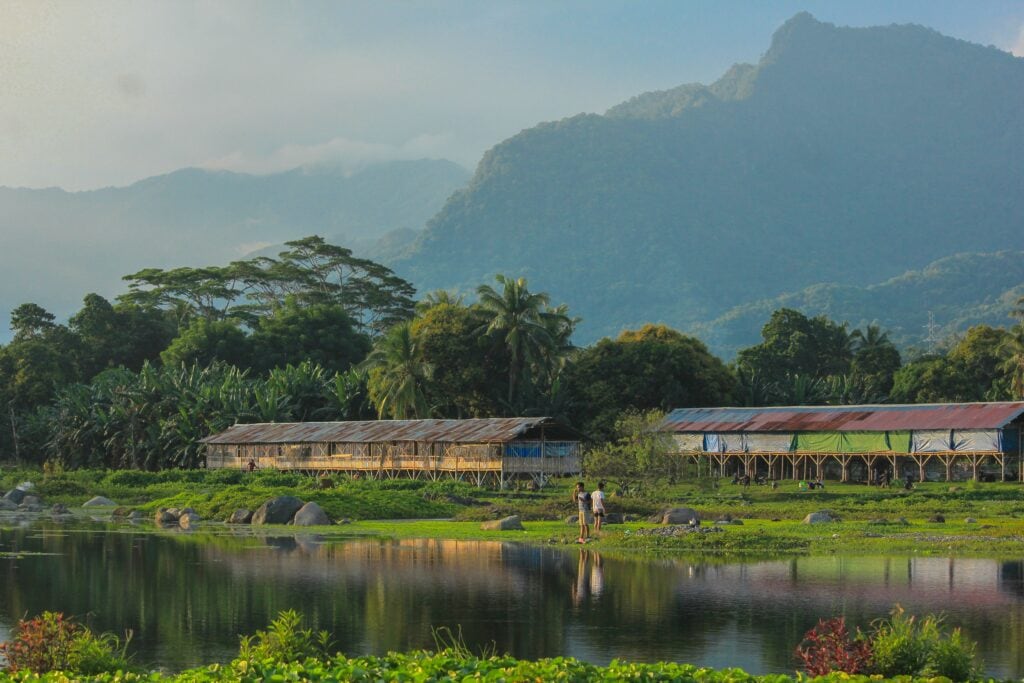 Wooden buildings surrounded by greenery near a lake in Ende, Indonesia Wooden buildings surrounded by greenery near a lake in Ende, Indonesia