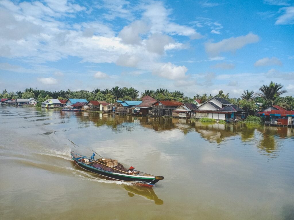 A boat travelling down a canal in Banjarmasin, Indonesia A boat travelling down a canal in Banjarmasin, Indonesia