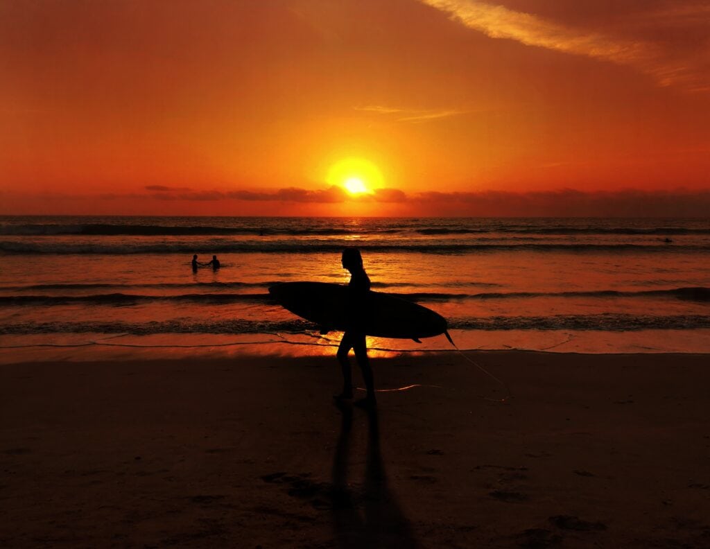 Surfer at sunset on a beach in Kuta, Indonesia Surfer at sunset on a beach in Kuta, Indonesia