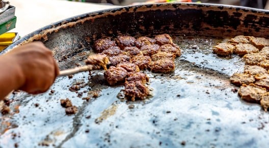 Circular kebabs being cooked on a hot plate Circular kebabs being cooked on a hot plate