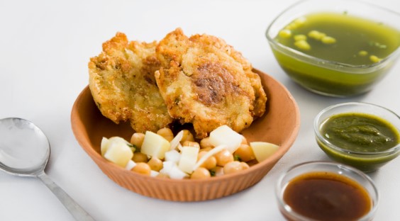 A bowl of Aloo Tikki an Indian potato patty served with a selection of chutneys A bowl of Aloo Tikki an Indian potato patty served with a selection of chutneys