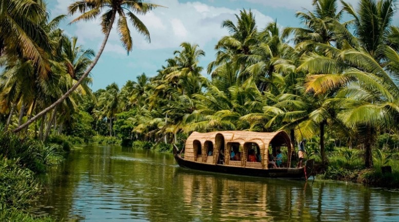 Straw roof boat travelling down the palm tree-boarded backwaters in Kerala Straw roof boat travelling down the palm tree-boarded backwaters in Kerala