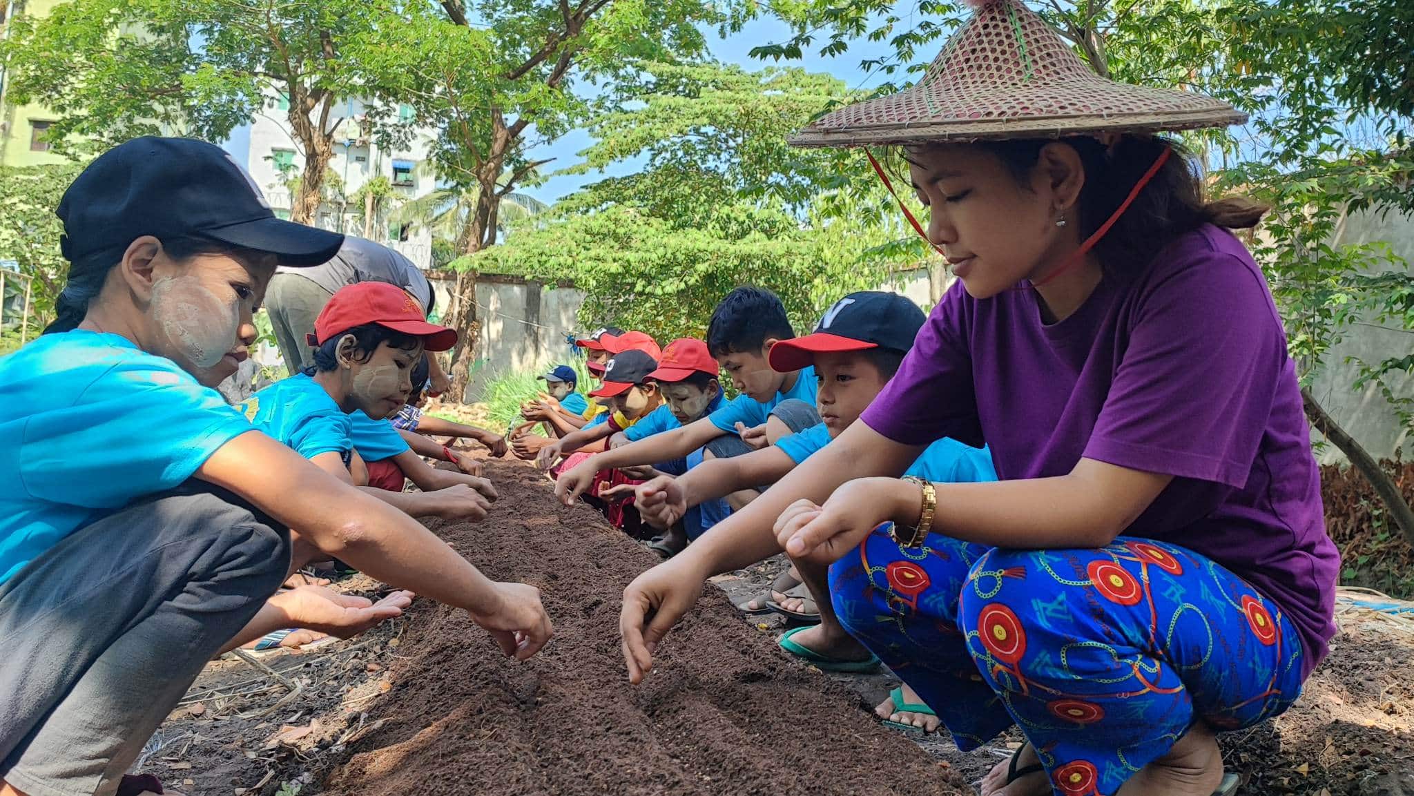 Myanmar trip (2) A row of happy children learn about organic farming at Kokkoya Organic Farm, Yangon, Myanmar